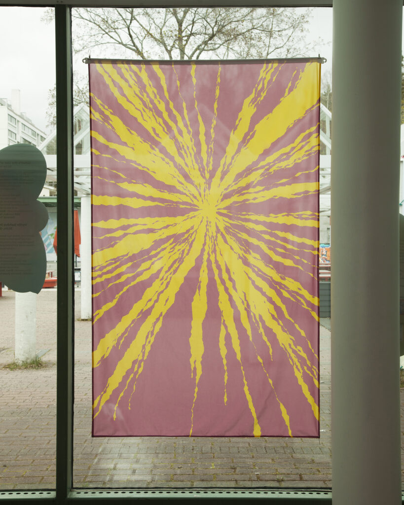 A pink and yellow flag in a window